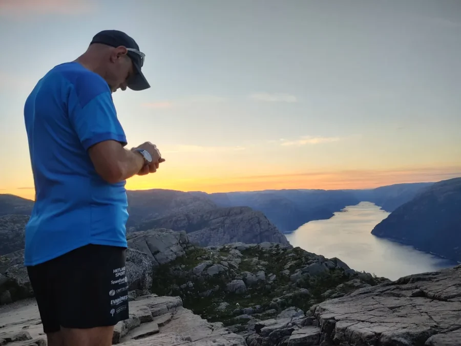 Trail runner heading towards Pulpit Rock at sunset, Norway