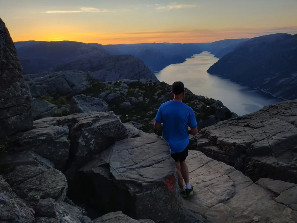 Trail runner heading towards Preikestolen at sunset